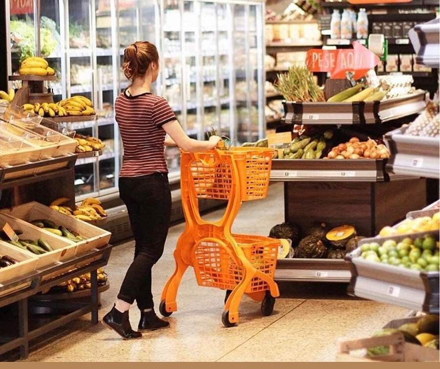 Na imagem aparece uma imagem de uma mulher com um carrinho laranja de supermercado. O carrinho é laranja