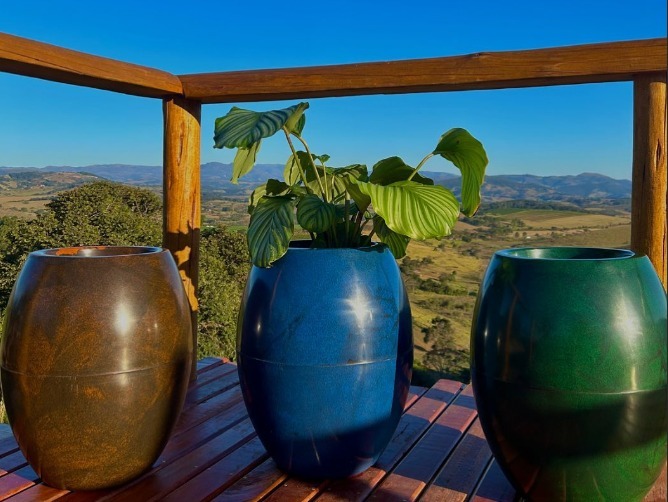 Vasos da cor azul, verde e marrom feitos de plástico reciclado.